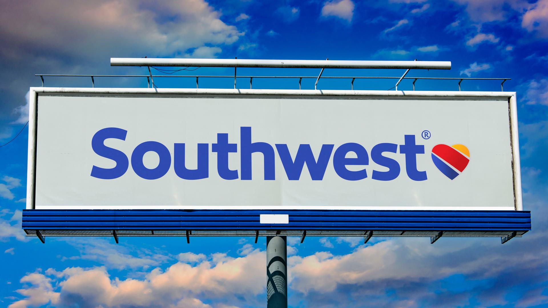 Eine Leuchtreklame der Fluggesellschaft Southwest Airlines. Dahinter blauer Himmel mit weißen Wolken.