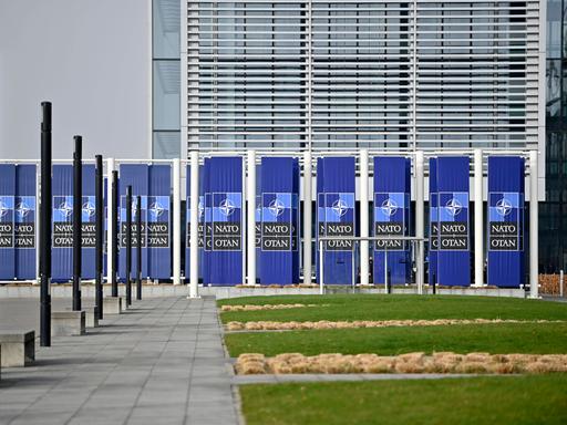 Das NATO-Hauptquartier in Brüssel von aussen, mit NATO-Logos vor der Tür.