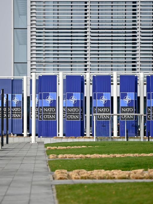 Das NATO-Hauptquartier in Brüssel von aussen, mit NATO-Logos vor der Tür.