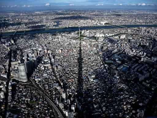 Blick über die Dächer von Tokyo, auf die der Schatten des Tokyo Sky Trees fällt.