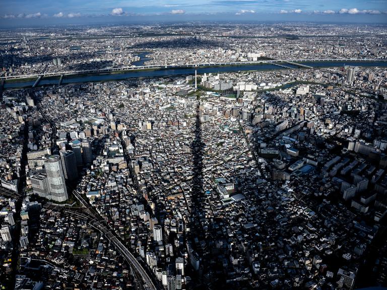 Blick über die Dächer von Tokyo, auf die der Schatten des Tokyo Sky Trees fällt.