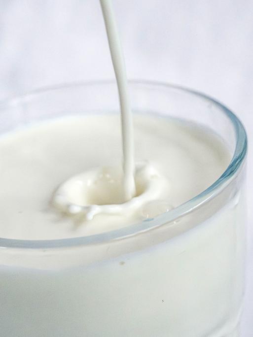 Milch wird in ein Glas gefüllt