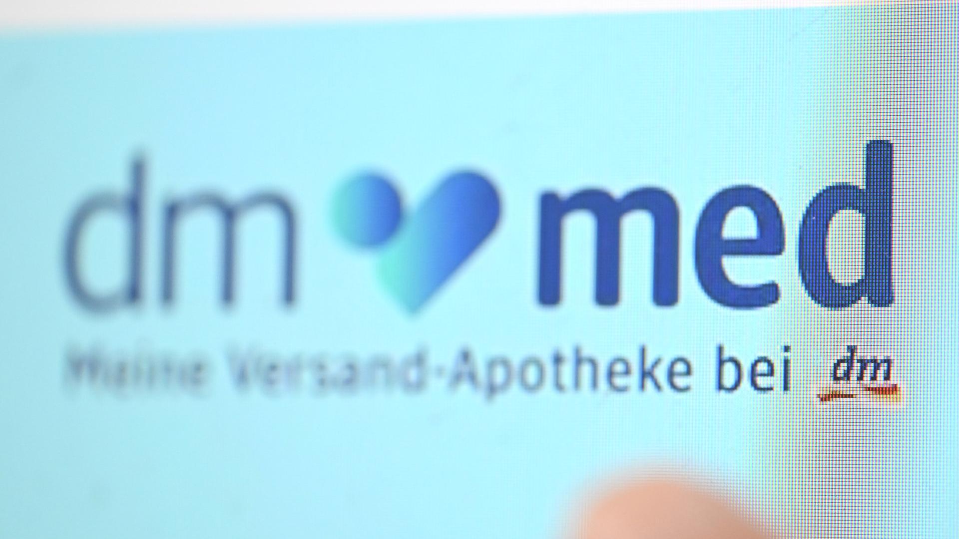 Das Logo der Online-Apotheke dm-med erscheint auf der Webseite von dm auf einem Computerbildschirm.