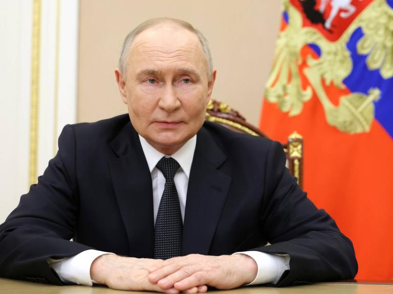 Russlands Präsident Putin am 28. Mai 2025 während einer Videoansprache, im Hintergrund eine Flagge Russlands