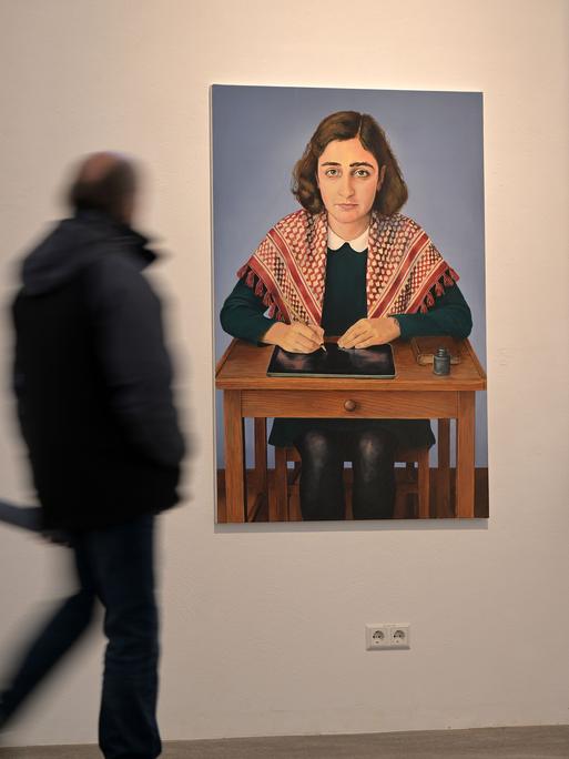 auf einem Genälde ist das im Holocaust ermordete jüdische Mädchen Anne Frank mit einer Kufiya, einem Palästinensertuch, zu sehen.