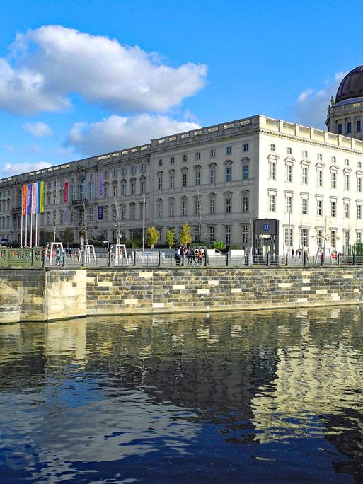 In der Mitte das Humboldt Forum in Berlin. Davor Wasser. Im Hintergrund ist links auch der Fernsehturm am Alexanderplatz zu erkennen.