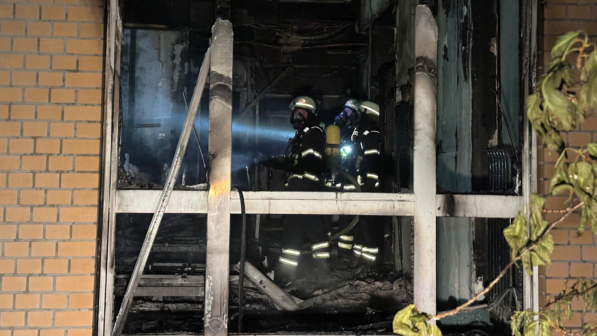 Feuerwehrleute mit Atemschutzgerät arbeiten in einem ausgebrannten Raum im Erdgeschoß im Marienkrankenhaus im Hamburger Stadtteil Hohenfelde. Feuerwehrleute mit Atemschutzgerät arbeiten in einem ausgebrannten Raum im Erdgeschoß im Marienkrankenhaus im Hamburger Stadtteil Hohenfelde.