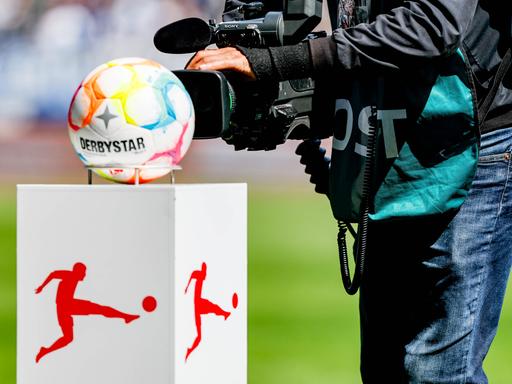 Ein Kamermann filmt die Präsentationssäule für den Spielball auf der das Logo der DFL (Deutsche Fußball Liga) aufgebracht ist.