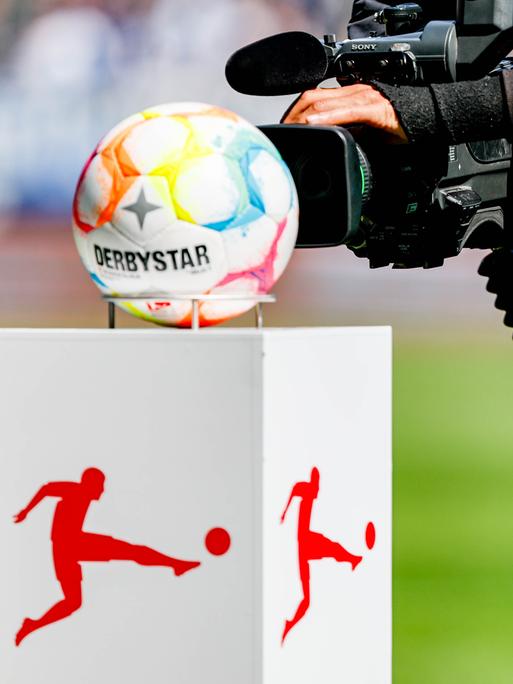 Ein Kamermann filmt die Präsentationssäule für den Spielball auf der das Logo der DFL (Deutsche Fußball Liga) aufgebracht ist.