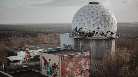 Ansicht der Abhöranlage auf dem Teufelsberg mit Graffities an den Wänden bei bedecktem Wetter im Winter.