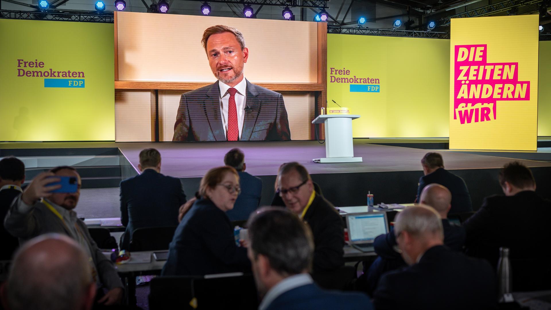 Eine große Videoleinwand zeigt Lindner in der Zuschaltung aus Washington. Vor der Leinwand sitzen Delegierte des Parteitages. Eine große Videoleinwand zeigt Lindner in der Zuschaltung aus Washington. Vor der Leinwand sitzen Delegierte des Parteitages.