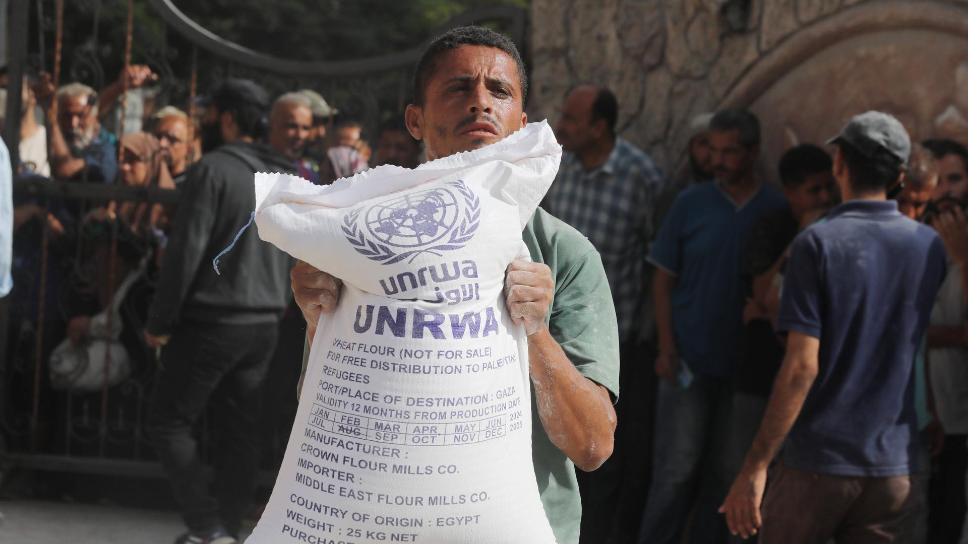 Ein Mann hält einen Sack mit Mehl in der Hand, den die türkische Hilfsorgansation AFAD für das Palästinenser-Hilfswerk UNRWA im Gazastreifen verteilt.