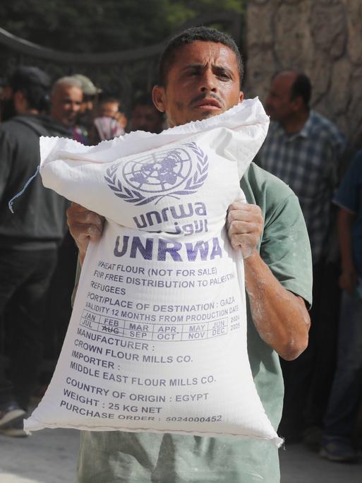 Ein Mann hält einen Sack mit Mehl in der Hand, den die türkische Hilfsorgansation AFAD für das Palästinenser-Hilfswerk UNRWA im Gazastreifen verteilt.