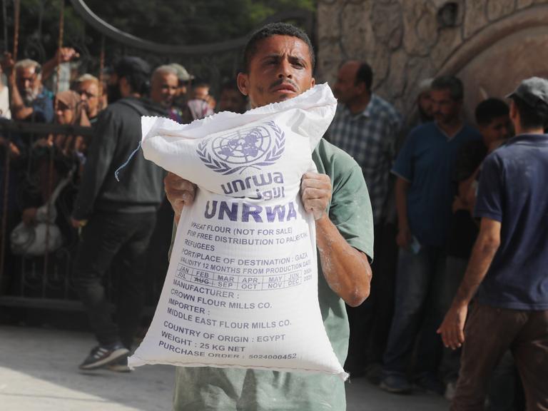 Ein Mann hält einen Sack mit Mehl in der Hand, den die türkische Hilfsorgansation AFAD für das Palästinenser-Hilfswerk UNRWA im Gazastreifen verteilt.