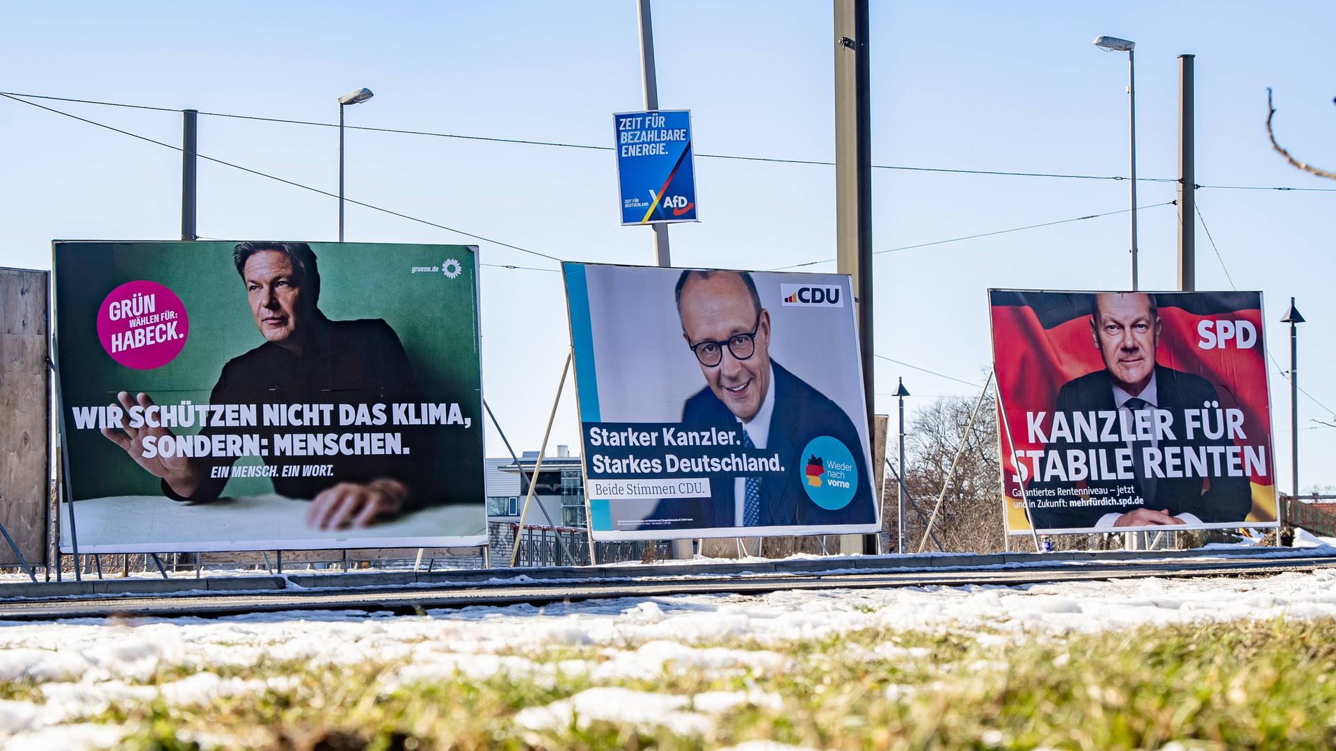 Wahlplakate der Kanzlerkandidaten der Grüne Robert Habeck, der CDU Friedrich Merz und der SPD Olaf Scholz in Berlin, dazu ein Plakat der AfD.