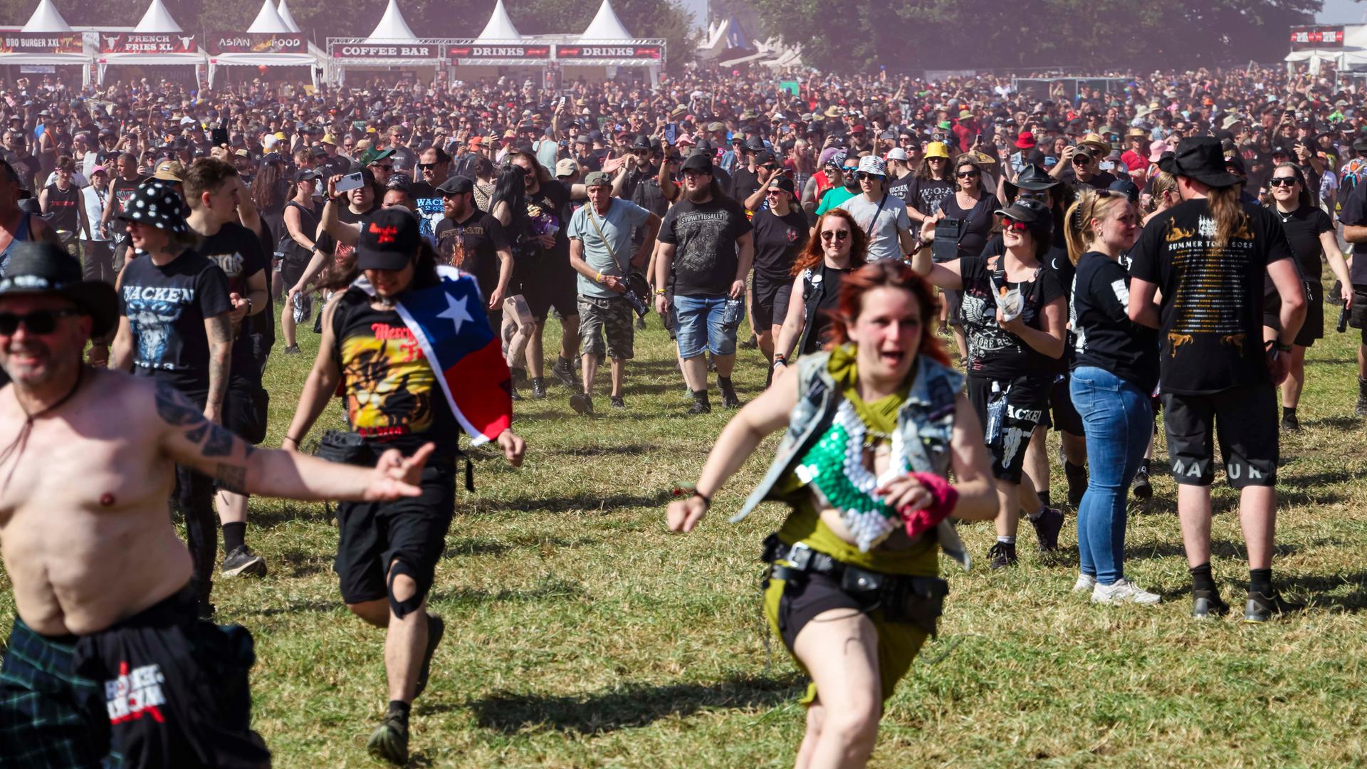 Festivalbesuchende laufen während der Eröffnung auf das Infield beim Wacken Open Air.