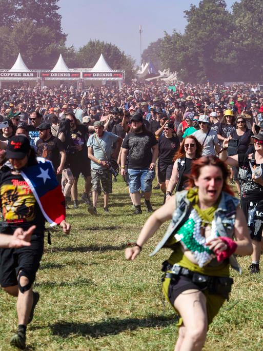 Festivalbesuchende laufen während der Eröffnung auf das Infield beim Wacken Open Air.