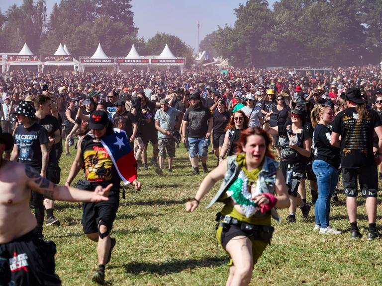 Festivalbesuchende laufen während der Eröffnung auf das Infield beim Wacken Open Air.