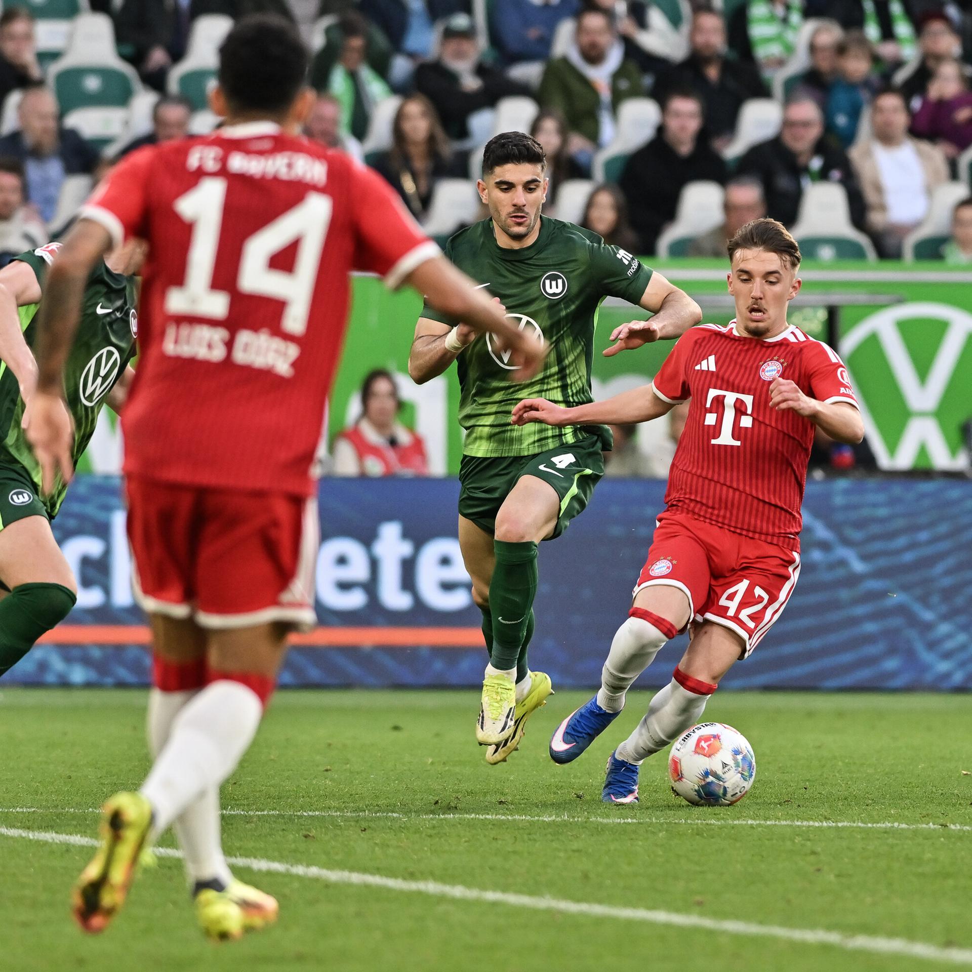 Spieler vom FC Bayern und VfL Wolfsburg kämpfen um den Ball.