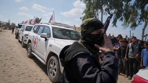 Chan Junis: Fahrzeugen des Roten Kreuzes mit freigelassenen Geiseln bahnen sich ihren Weg durch Gruppen von Palästinensern und Hamas-Bewaffneten auf dem Weg zur israelischen Grenze.