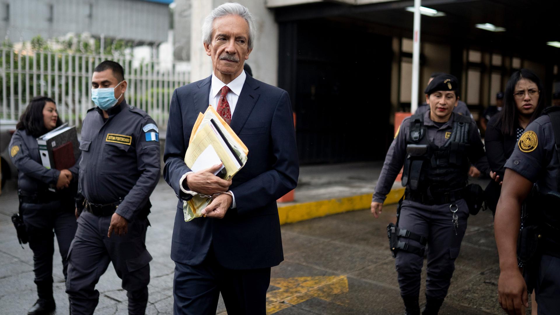 "El Periódico"-Gründer Zamora vor einem Gerichtsgebäude in Guatemala City. Neben ihm sind Polizisten zu sehen. 