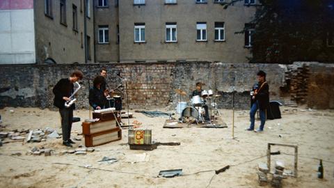 Privat organisiertes Punkkonzert in einem Ostberliner Hinterhof im Mai 1985. Vier Musiker spielen und singen in einem leeren Hinterhof vor einer bröckelnden Mauer. 