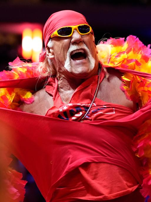 Der schwer muskulöse Hulk Hogan reißt sich auf einer Bühne sein T-Shirt vom Leib