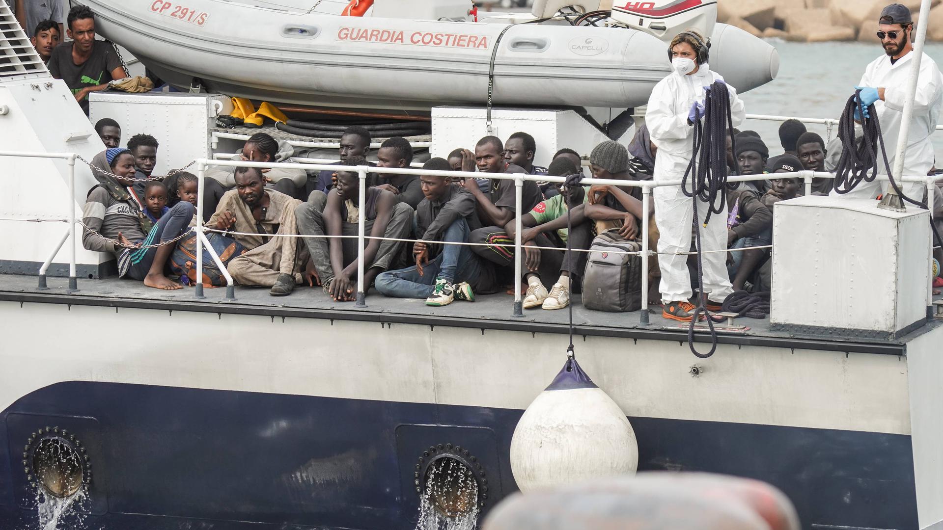 Mehrere Geflüchtete kommen auf einem Schiff auf der italienischen Insel Lampedusa an.