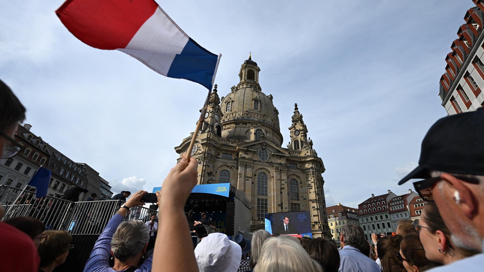 Ein Festbesucher schwenkt eine Frankreich-Fahne während der Rede von Emmanuel Macron, Präsident von Frankreich, beim Europäischen Jugendfest «Fête de l'Europe» auf dem Neumarkt vor der Frauenkirche. 