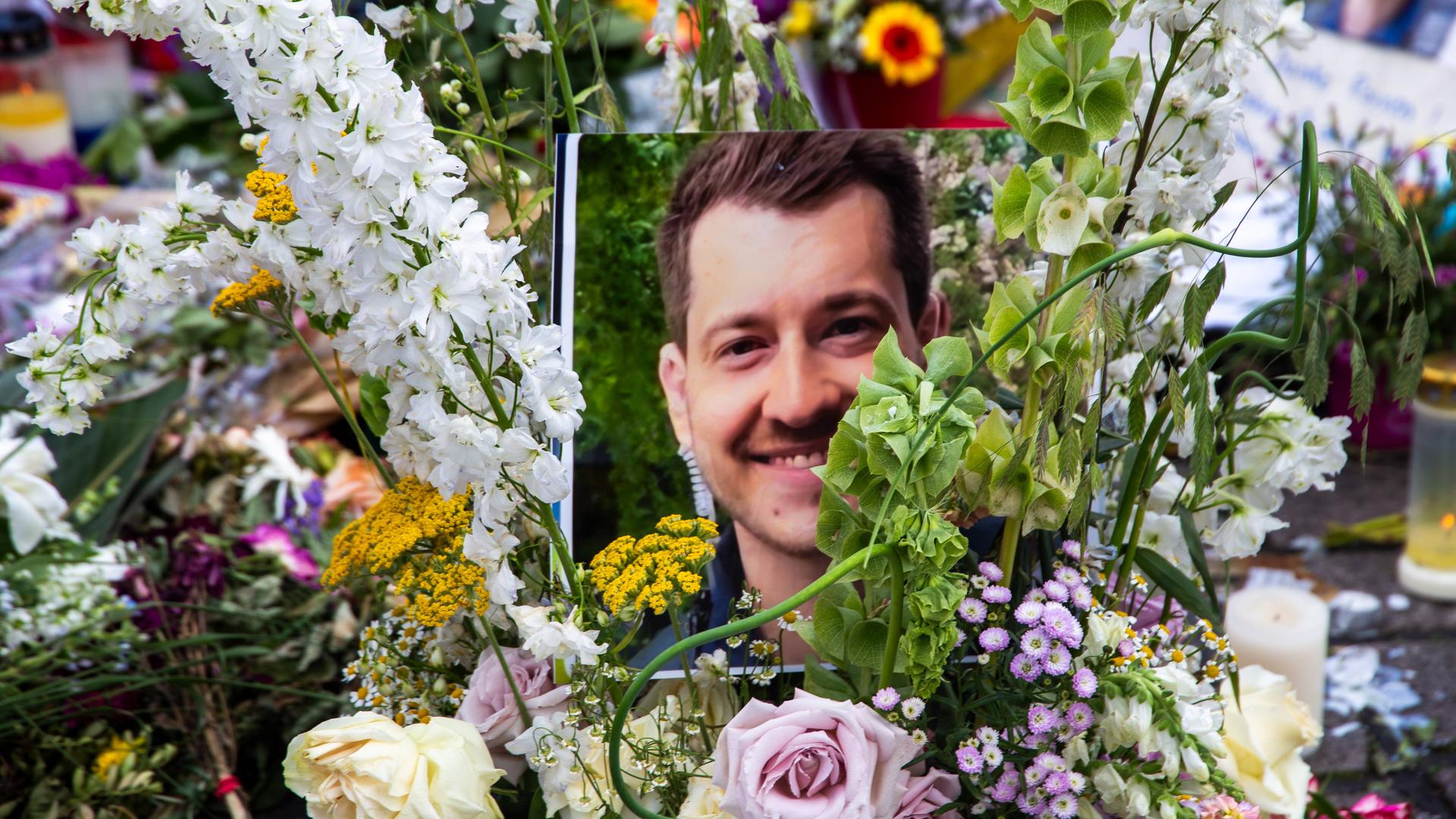 Ein Foto des getöteten Polizisten Rouven Laur in einem bunten Blumenstrauß.