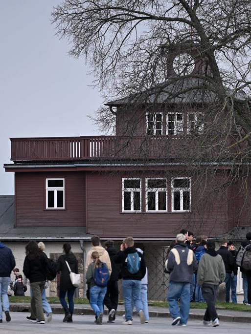Das Lagertor der Gedenkstätte Buchenwald. Davor stehen Besucher des früheren Konzentrationslagers. 