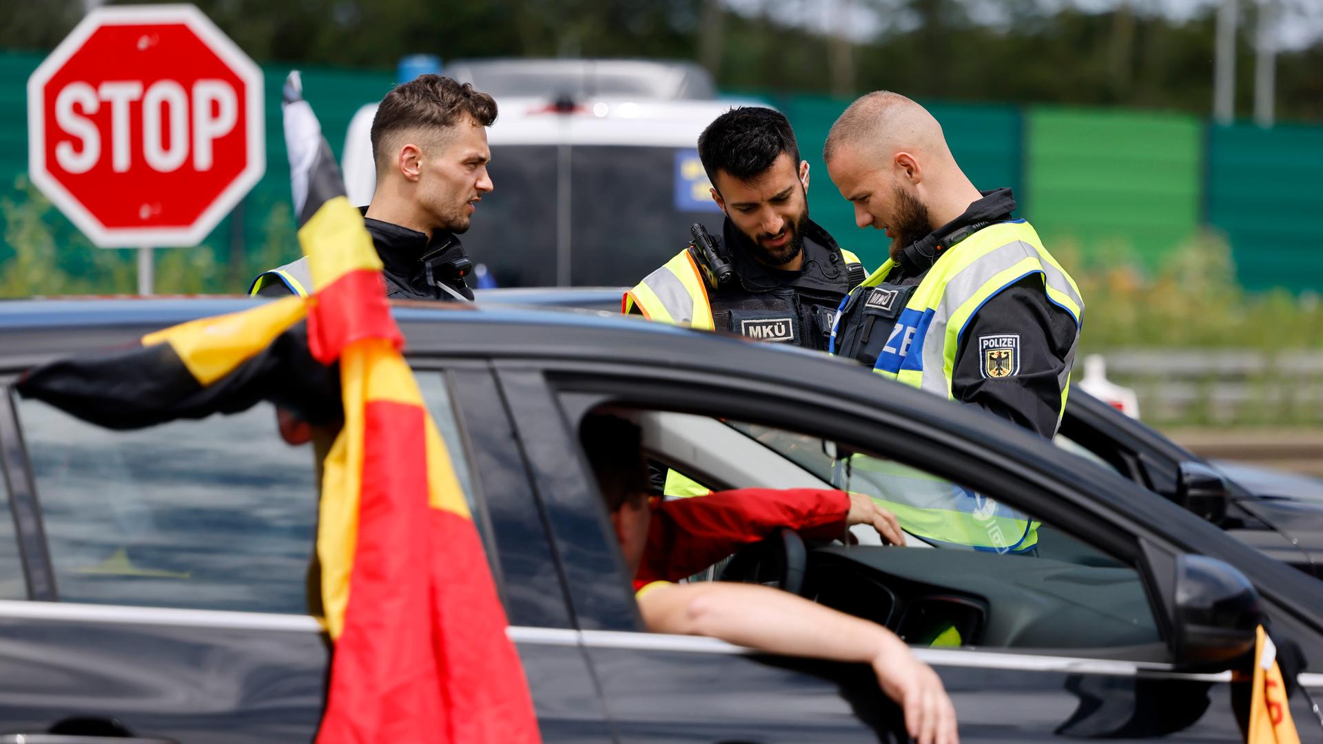 Polizisten kontrollieren bei Aachen Fahrzeuginsassen und Papiere. 