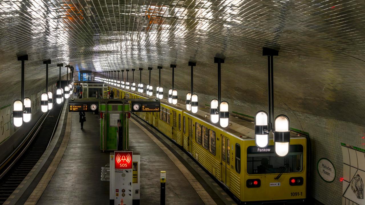 Innenaufnahme der U-Bahnstation Märkisches Museum in Berlin. Auf einem Gleis steht eine gelbe Bahn mit Fahrziel Pankow.