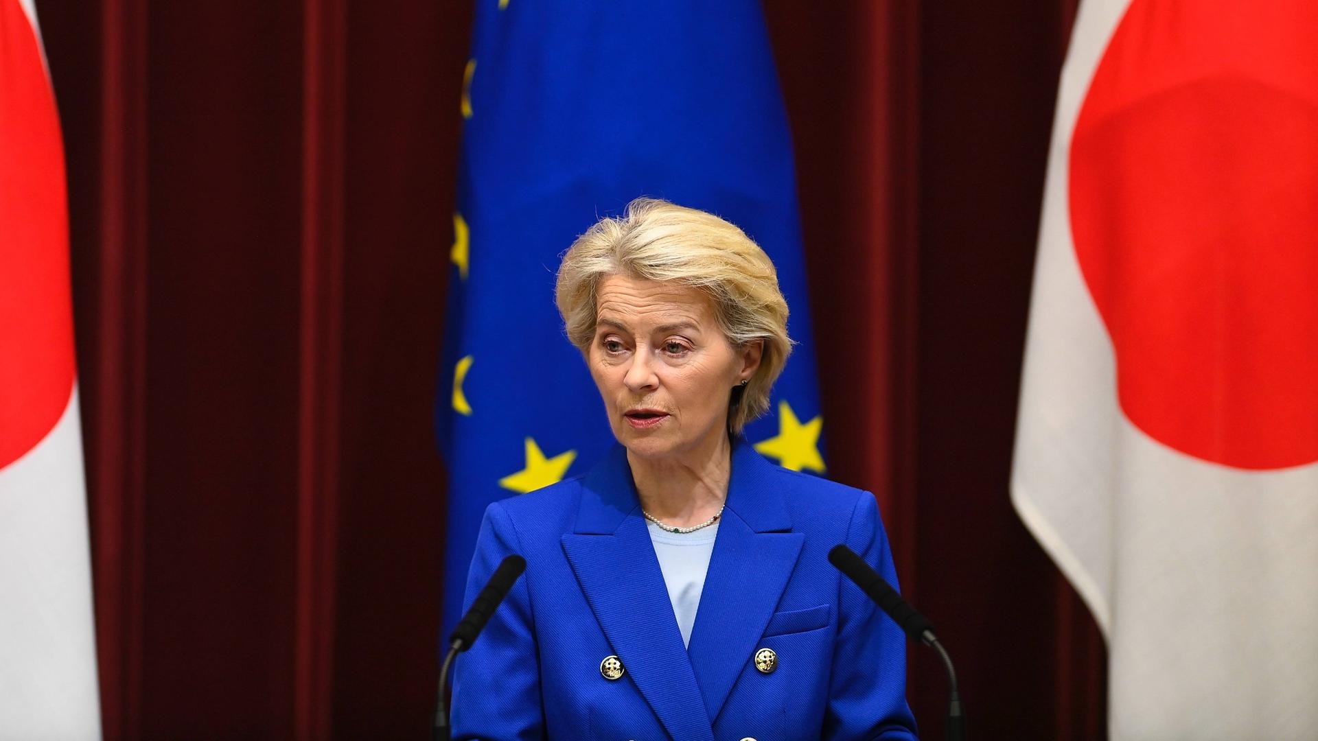 EU-Kommissionspräsidentin von der Leyen spricht beim EU-China-Gipfel in Tokio, hinter ihr die EU-Fahne.