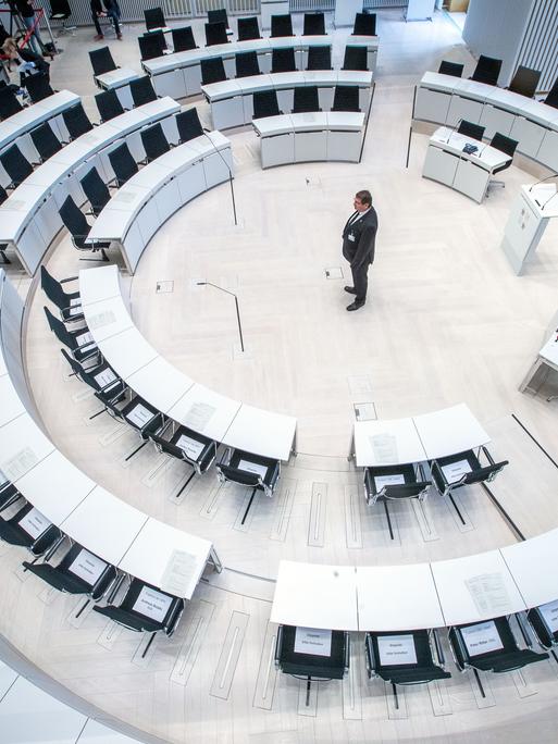 Ein Landtagsmitarbeiter prüft die Sitzordnung mit größeren Abständen zwischen den Abgeordnetenplätzen vor dem Beginn einer Landtagssitzung im Jahr 2020 mit dezimierter Beteiligung