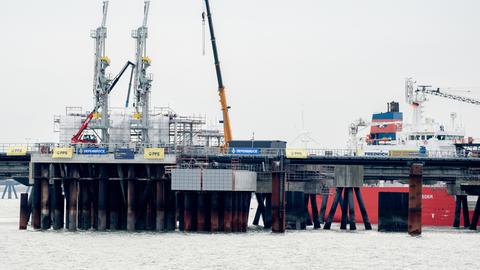 Technische Anlagen und ein Kran stehen auf dem Anleger für das LNG-Terminal in der Nordsee vor Wilhelmshaven. Der erste Anleger für Flüssigerdgas (LNG) in Deutschland ist fertiggestellt und am Dienstag eröffnet worden. In rund einem Monat soll ein beladenes Spezialschiff, eine sogenannte schwimmende Speicher- und Regasifizierungsanlage (FSRU), an dem Landungsplatz anlegen.