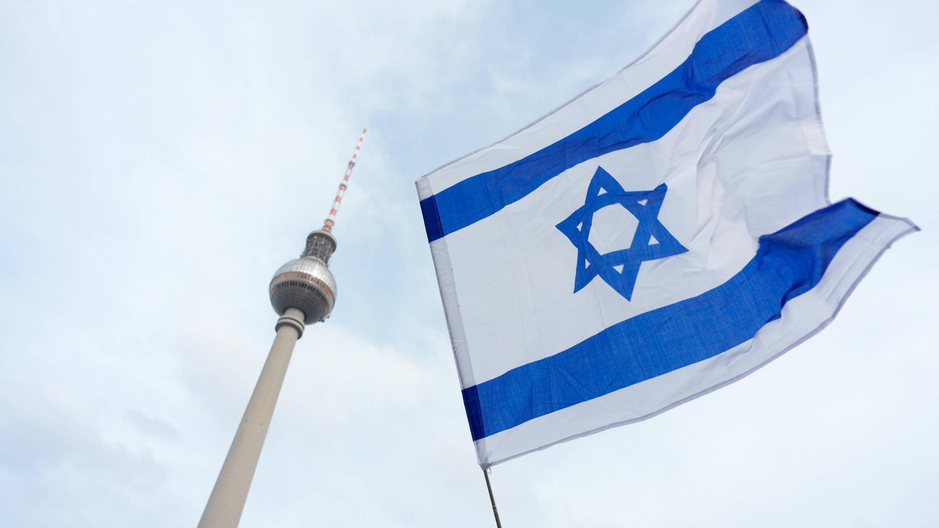 Ein israelische Flagge und im HIntergrund der Fernsehturm von Berlin.