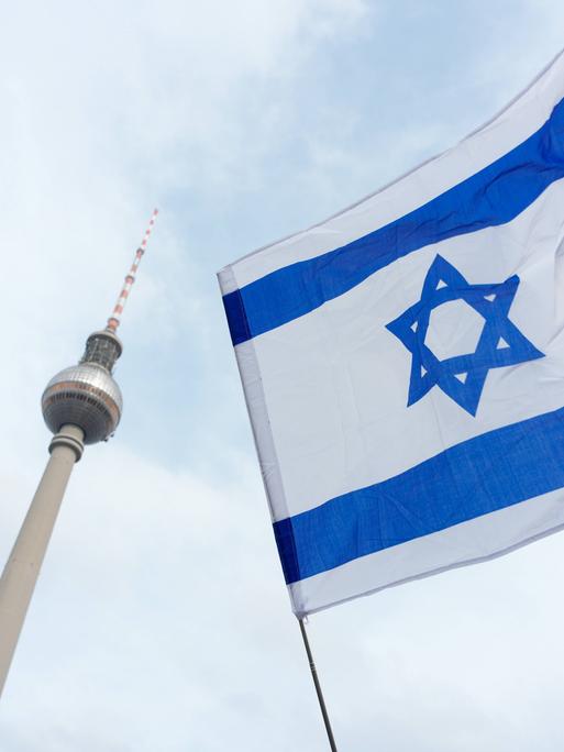 Ein israelische Flagge und im HIntergrund der Fernsehturm von Berlin.