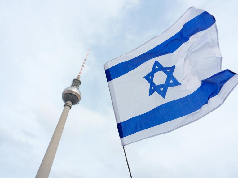Ein israelische Flagge und im HIntergrund der Fernsehturm von Berlin.