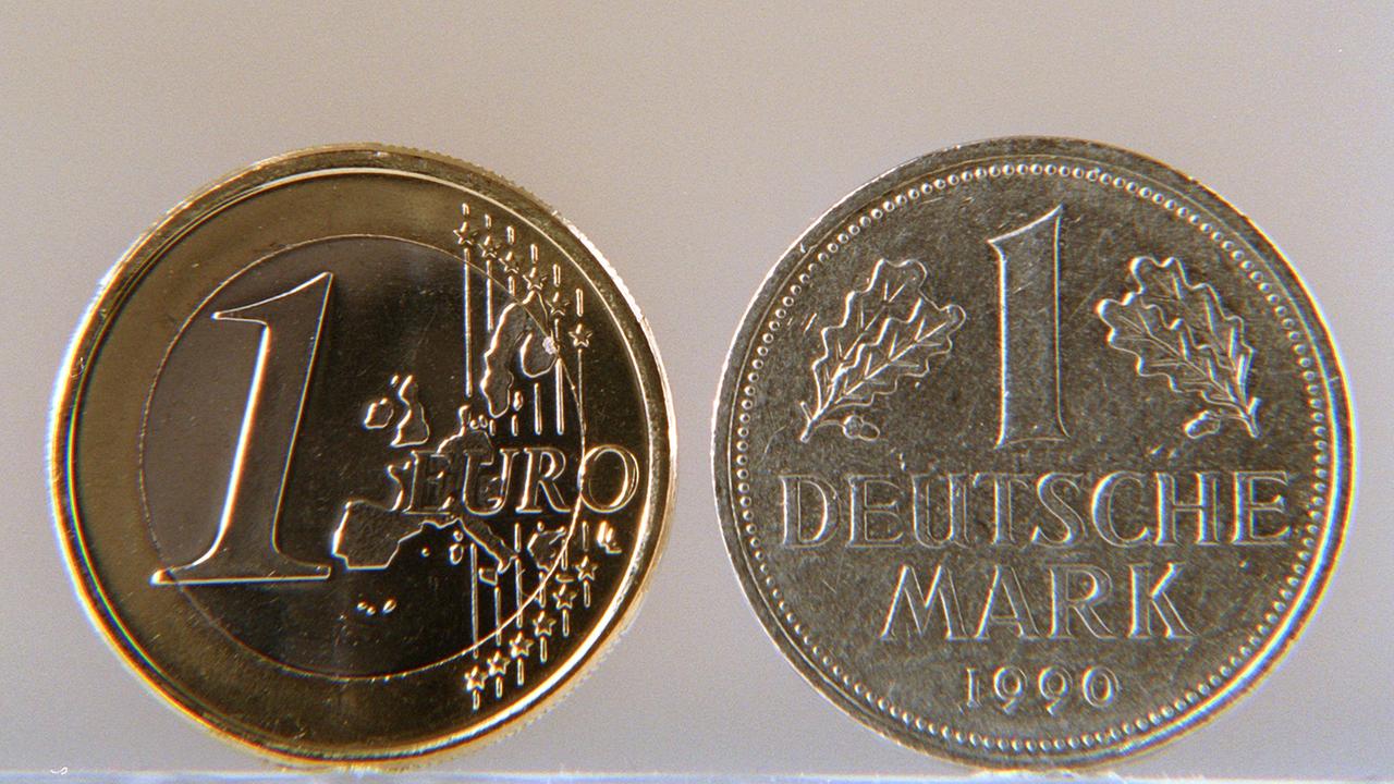 Eine Euro-Münze und eine D-Mark.