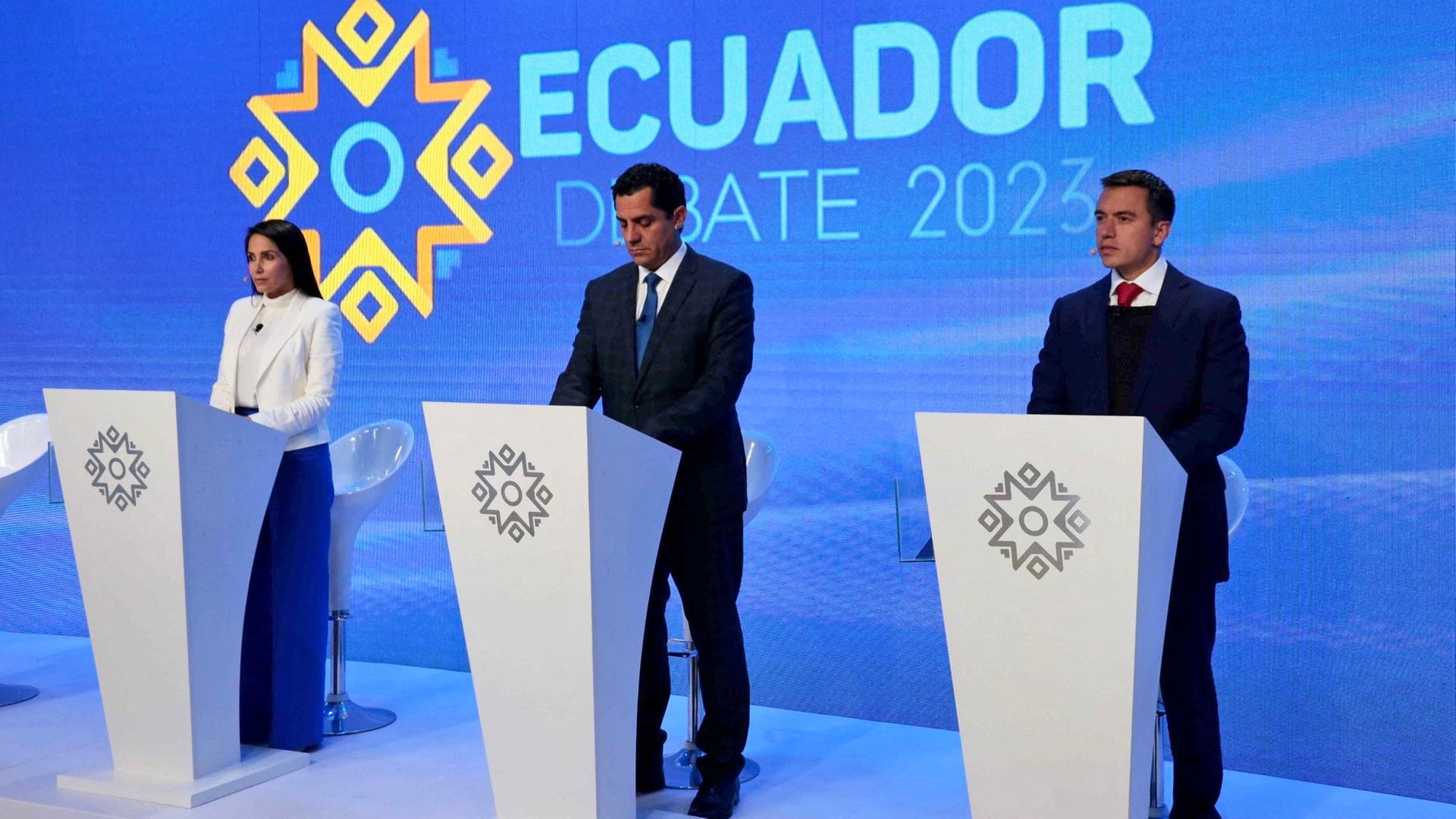 Die Präsidentschaftskandidaten Gonzalz, Hervaz und Noboa stehen bei einem Fernseh-Duell nebeneinander an jeweils einem weißen Rednerpult.