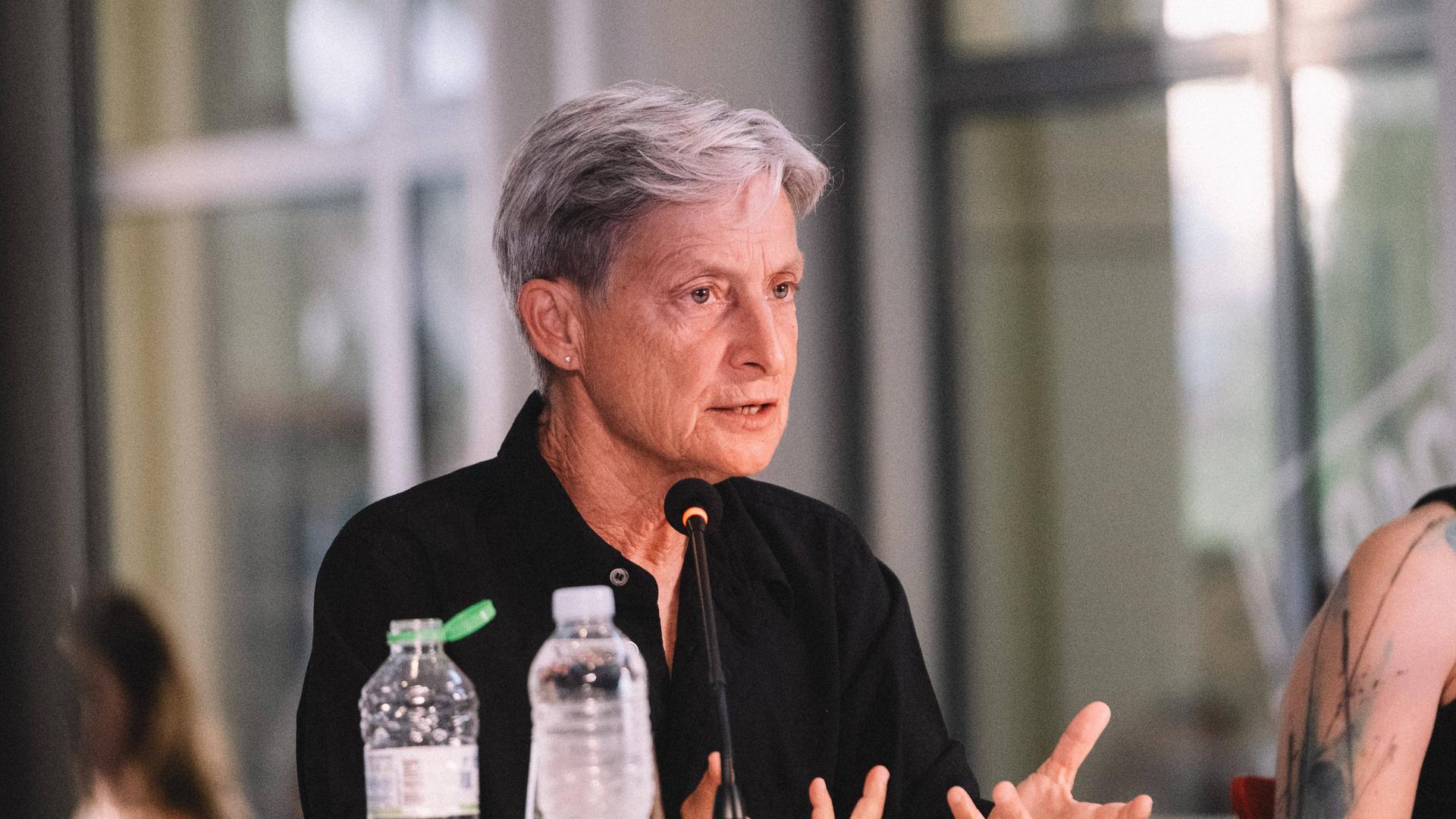 Judith Butler sitzt an einem Tisch und spricht bei der Vorstellung ihres Buches "Wer hat Angst vor Gender?" 