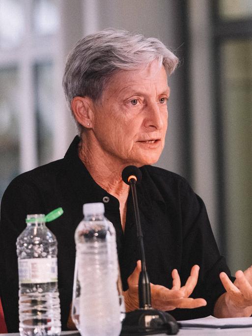 Judith Butler sitzt an einem Tisch und spricht bei der Vorstellung ihres Buches "Wer hat Angst vor Gender?" 