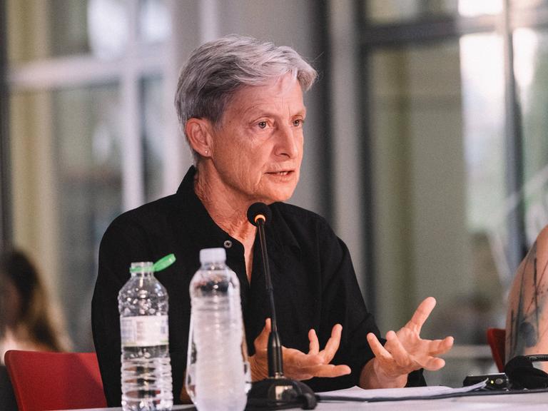 Judith Butler sitzt an einem Tisch und spricht bei der Vorstellung ihres Buches "Wer hat Angst vor Gender?" 