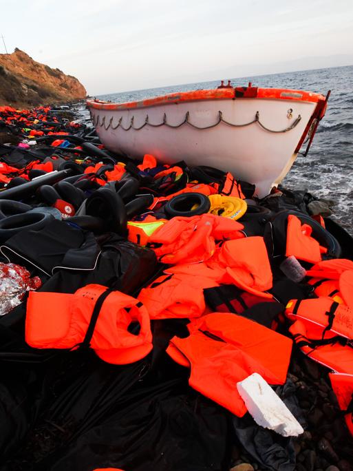 Ein Boot und ein Berg Rettungswesten liegen an der Küste von Lesbos. (2015)
