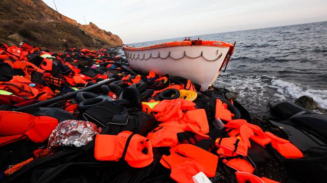 Ein Boot und ein Berg Rettungswesten liegen an der Küste von Lesbos. (2015)