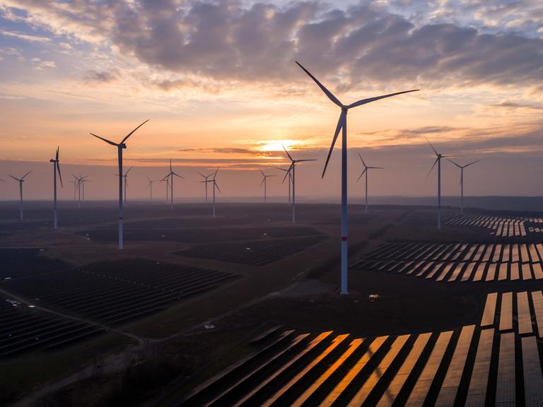 Solaranlagen und Windräder sind im Energiepark Lausitz bei Klettwitz bei Sonnenuntergang zu sehen. 