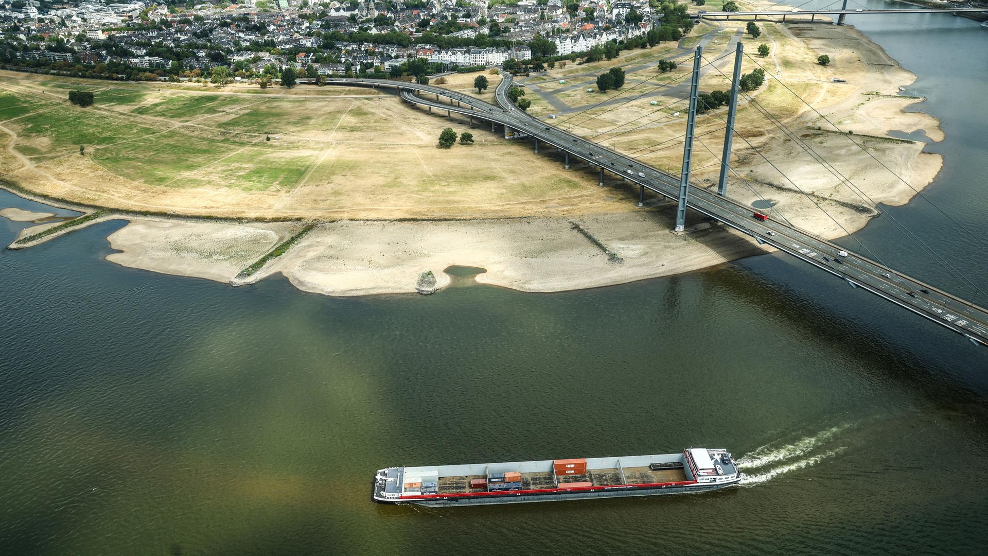 Ein Containerschiff fährt mit geringer Ladung bei Niedrigwasser am Rheinknie in Düsseldorf vorbei. Ein Containerschiff fährt mit geringer Ladung bei Niedrigwasser am Rheinknie in Düsseldorf vorbei.
