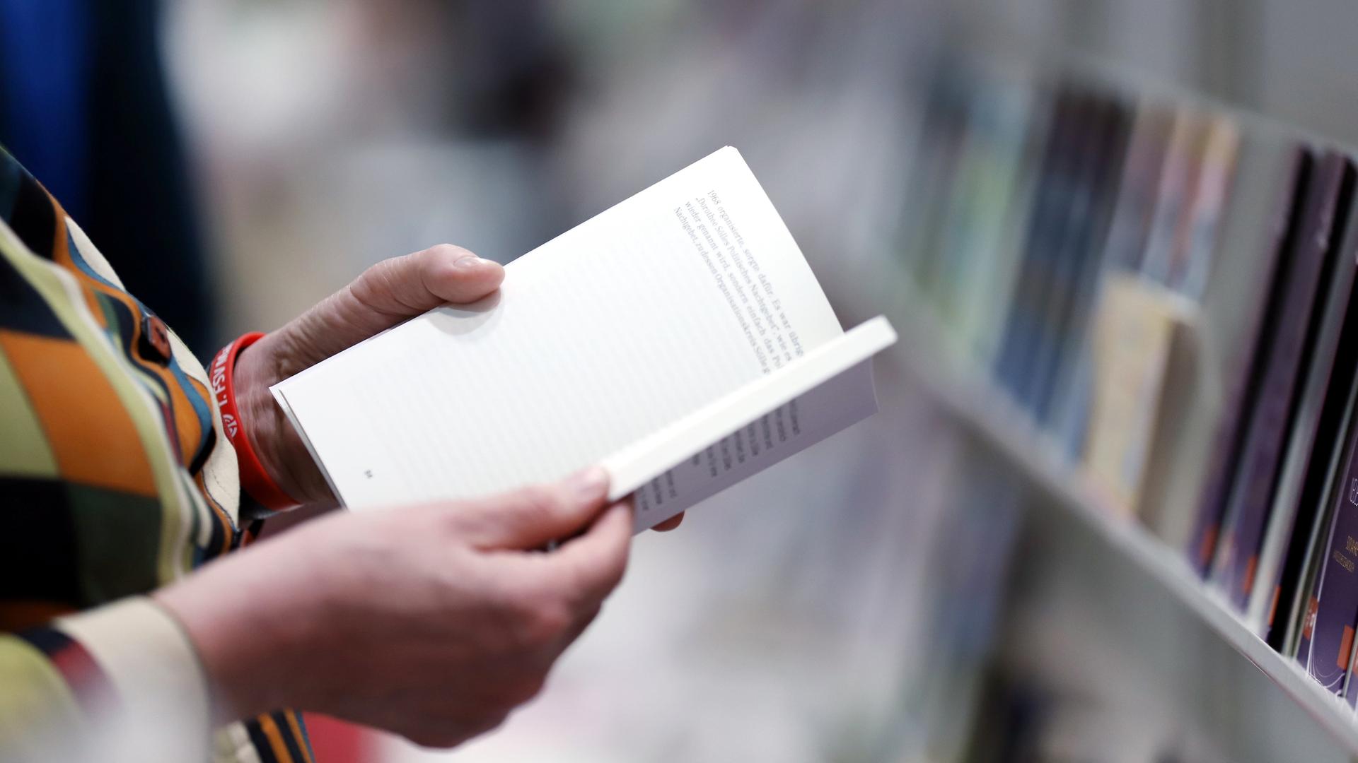 Eine Frau blättert durch ein Buch. 