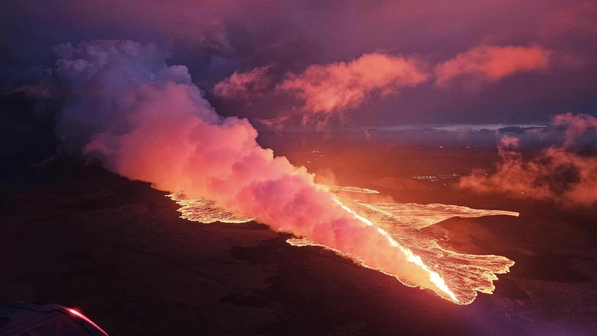 Eine rote, leuchtende Lava- und Rauchmasse wälzt sich den Vulkan herunter. Eine rote, leuchtende Lava- und Rauchmasse wälzt sich den Vulkan herunter.